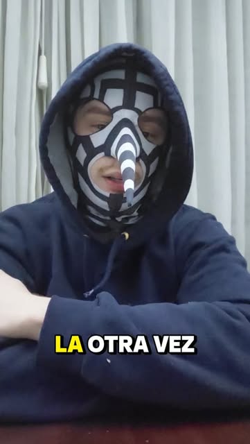 Licenciado Dengue enmascarado, sentado frente a una mesa
